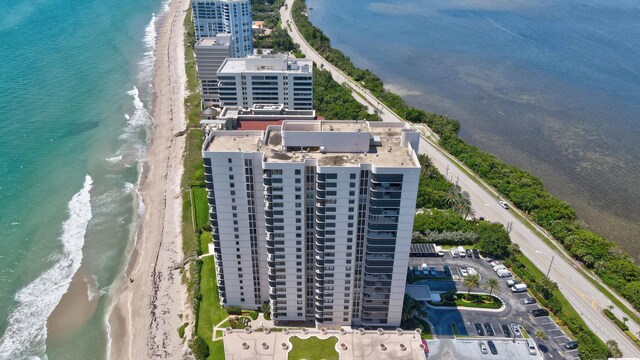 bird's eye view with a water view and a beach view