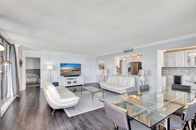 living room featuring crown molding, dark hardwood / wood-style floors, a textured ceiling, and beverage cooler