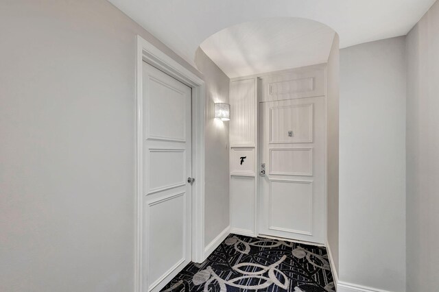 hallway featuring dark tile patterned flooring