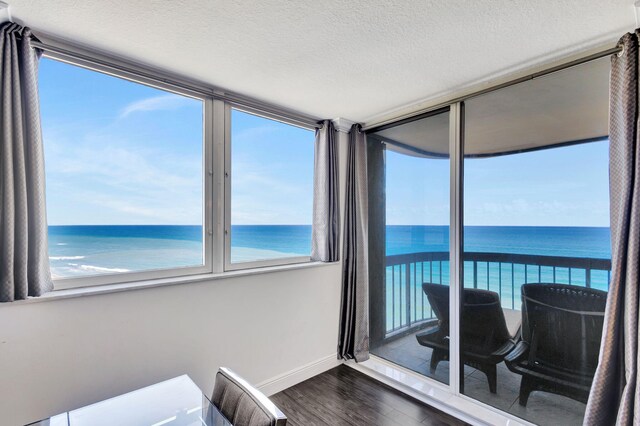 sunroom featuring plenty of natural light and a water view