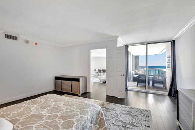 bedroom featuring a water view, crown molding, access to exterior, and floor to ceiling windows