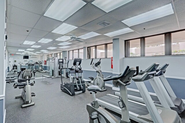 workout area with a paneled ceiling and ceiling fan