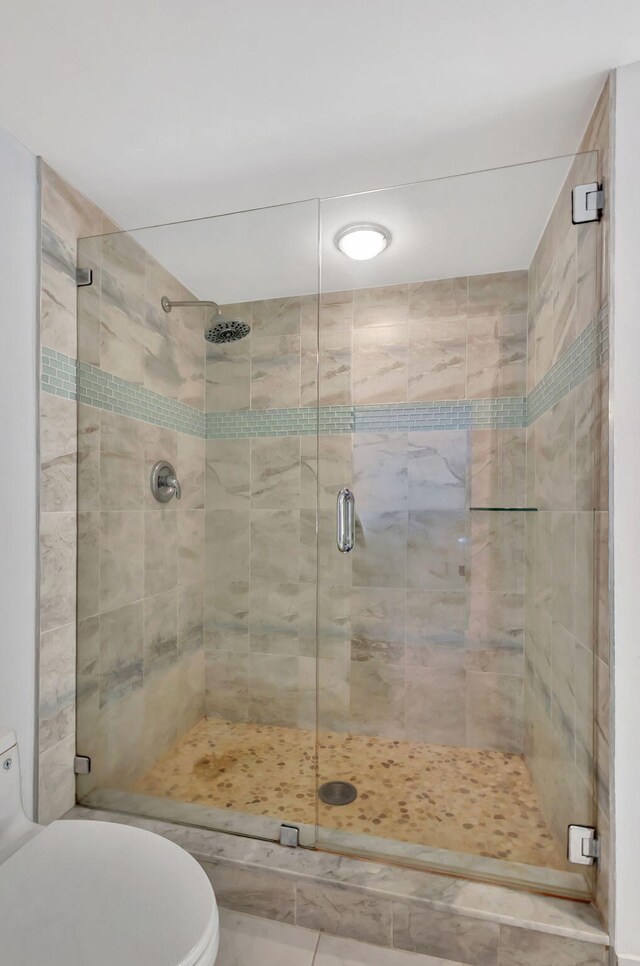 bathroom with toilet and an enclosed shower