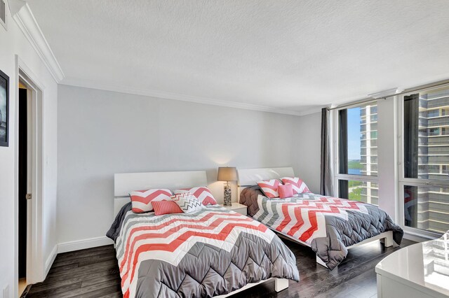 bedroom featuring crown molding, a textured ceiling, and dark hardwood / wood-style floors