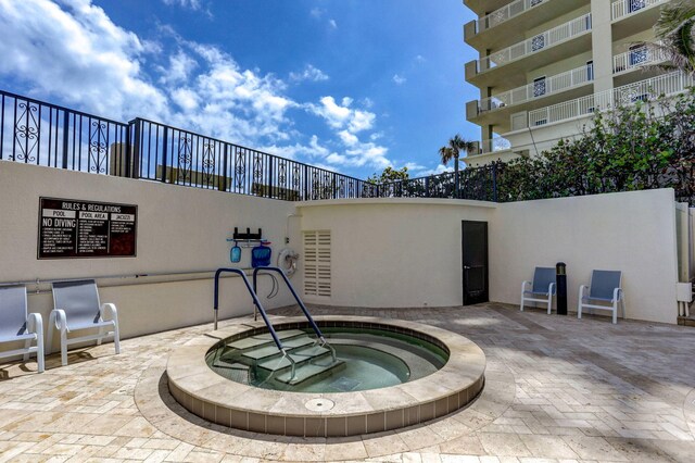 view of swimming pool with a hot tub and a patio