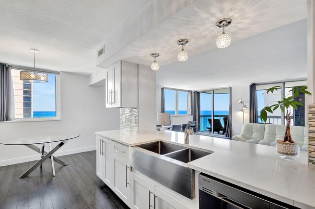 kitchen with dishwasher, white cabinets, decorative light fixtures, and dark hardwood / wood-style floors