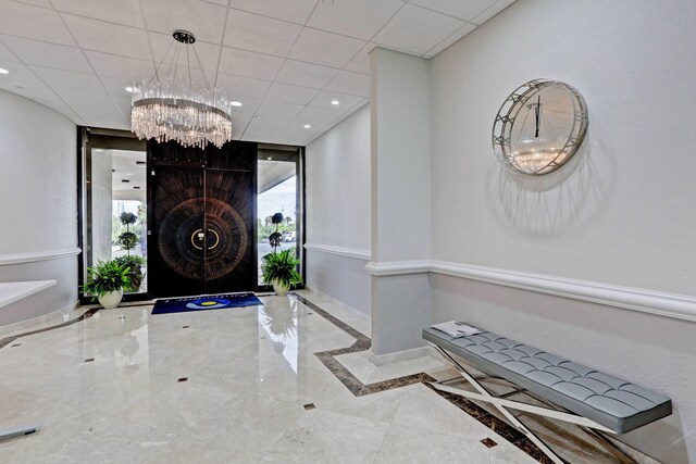 foyer with a drop ceiling and expansive windows