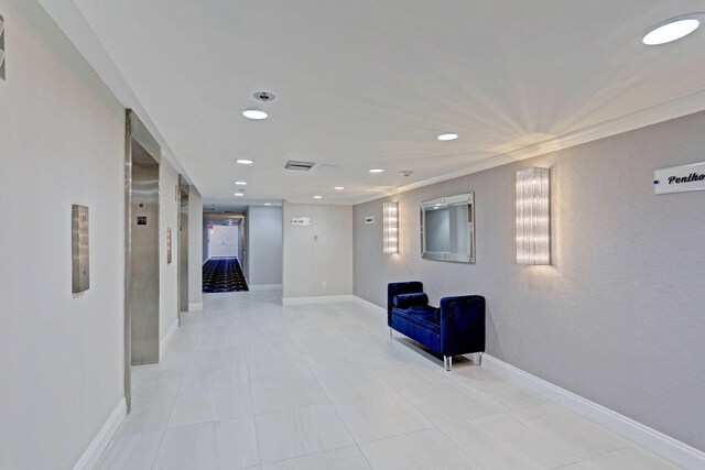 interior space with crown molding and light tile patterned floors