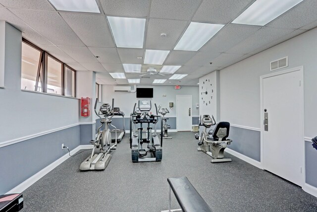 exercise room featuring a drop ceiling and a wall unit AC