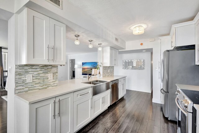 kitchen with backsplash, appliances with stainless steel finishes, dark hardwood / wood-style floors, and white cabinets