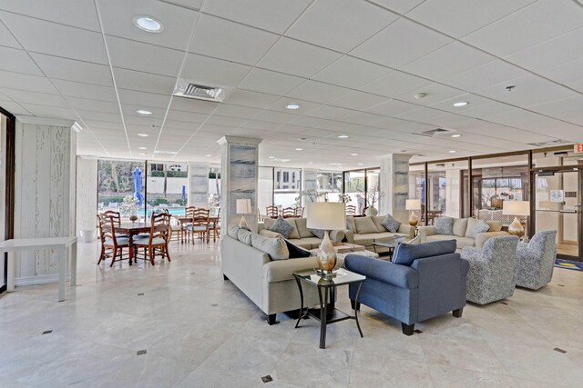 living room with expansive windows and a drop ceiling