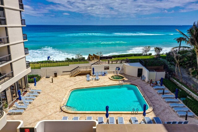 view of pool with a patio and a water view