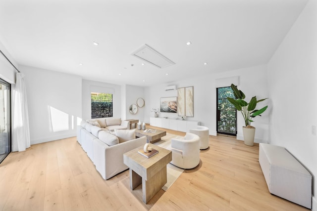 living room featuring light wood-type flooring and a wall unit AC