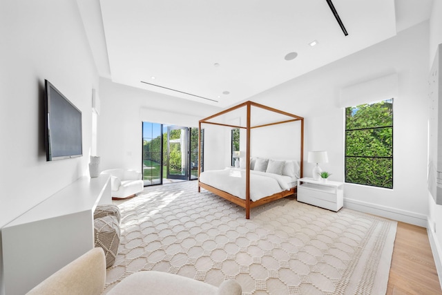 bedroom featuring light hardwood / wood-style floors, access to exterior, and multiple windows