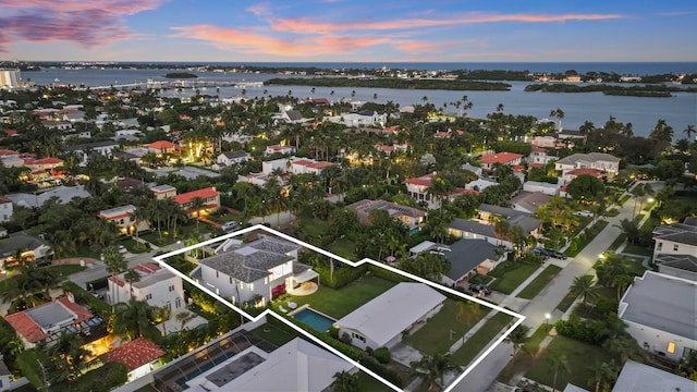 aerial view at dusk featuring a water view