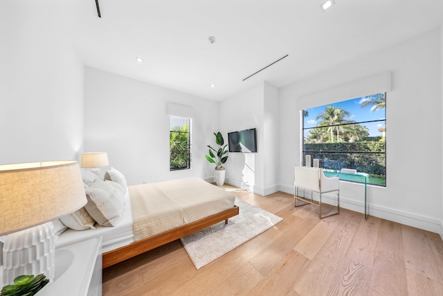 bedroom featuring light hardwood / wood-style flooring and multiple windows