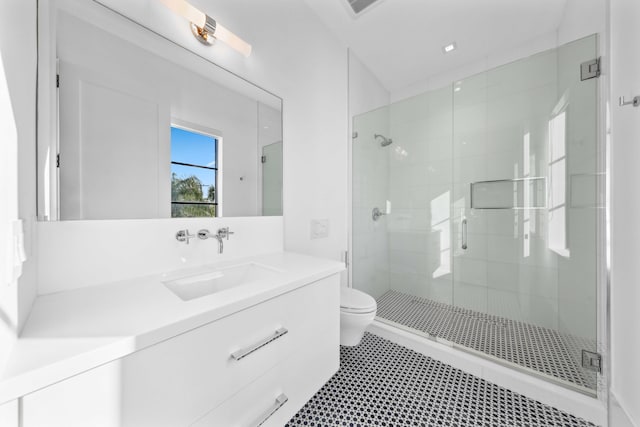 bathroom featuring vanity, toilet, and a shower with shower door