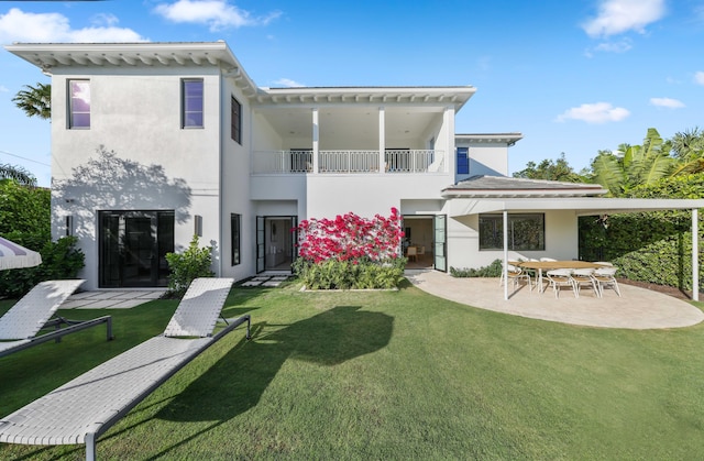 back of house featuring a patio, a balcony, and a lawn