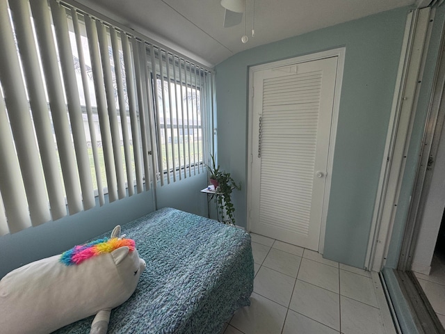 bedroom with vaulted ceiling, ceiling fan, a closet, and light tile patterned floors