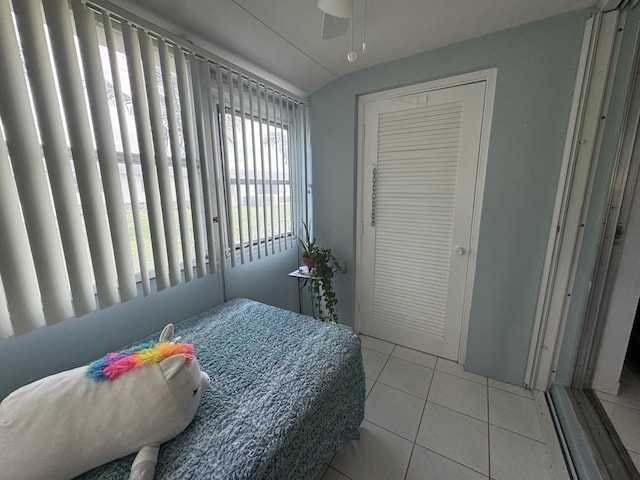 bedroom featuring ceiling fan, lofted ceiling, and light tile patterned floors