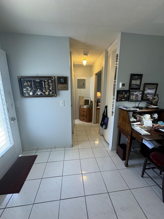 interior space with light tile patterned flooring and electric panel
