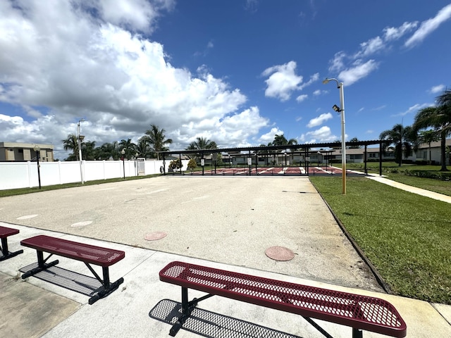 view of community with a lawn and fence