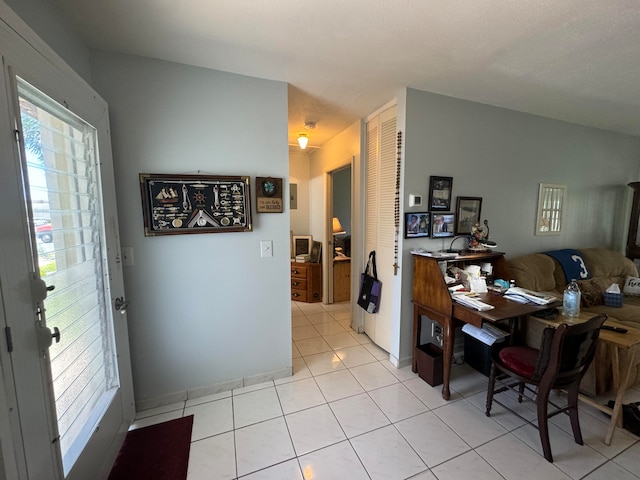 interior space featuring light tile patterned flooring and vaulted ceiling