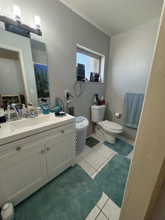 full bathroom with curtained shower, tile patterned flooring, vanity, and toilet
