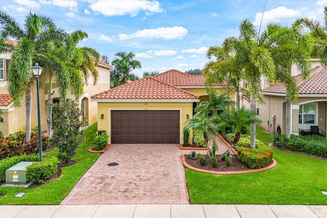 mediterranean / spanish-style house featuring a front yard and a garage