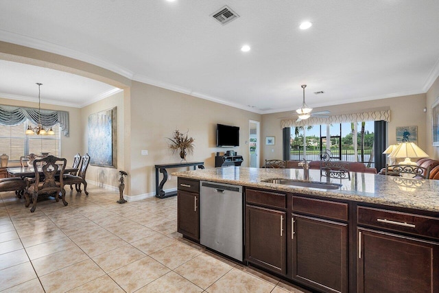 kitchen with light stone counters, stainless steel dishwasher, hanging light fixtures, and sink