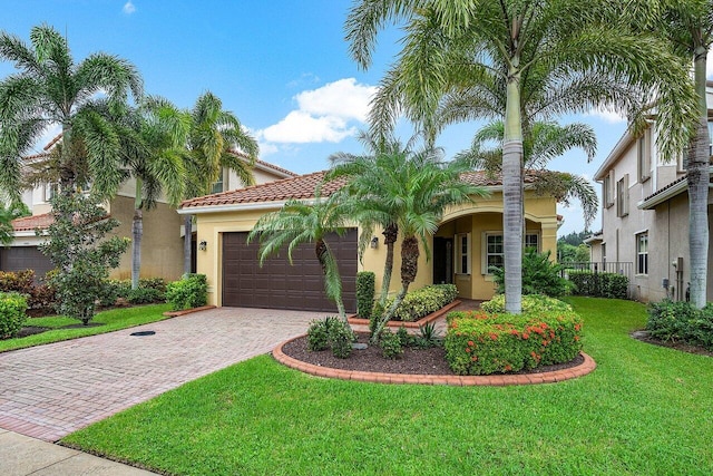 mediterranean / spanish house with a front yard and a garage