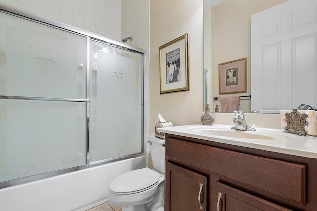 full bathroom featuring tile patterned floors, vanity, toilet, and shower / bath combination with glass door