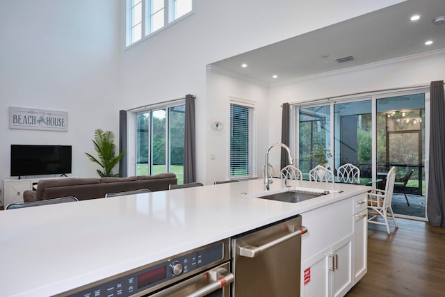 kitchen with sink, dishwasher, white cabinetry, and plenty of natural light