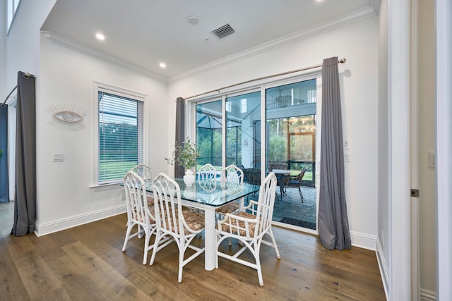 dining space with crown molding and dark hardwood / wood-style flooring