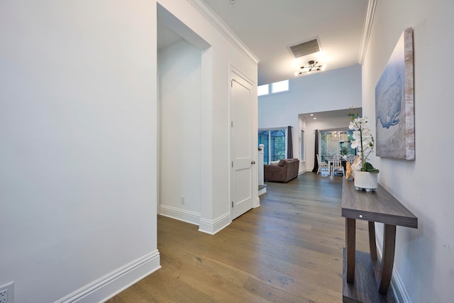 corridor featuring ornamental molding and hardwood / wood-style flooring