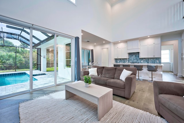 living room with light hardwood / wood-style flooring and a towering ceiling