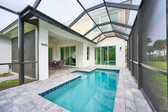 view of swimming pool with a patio, ceiling fan, and a lanai