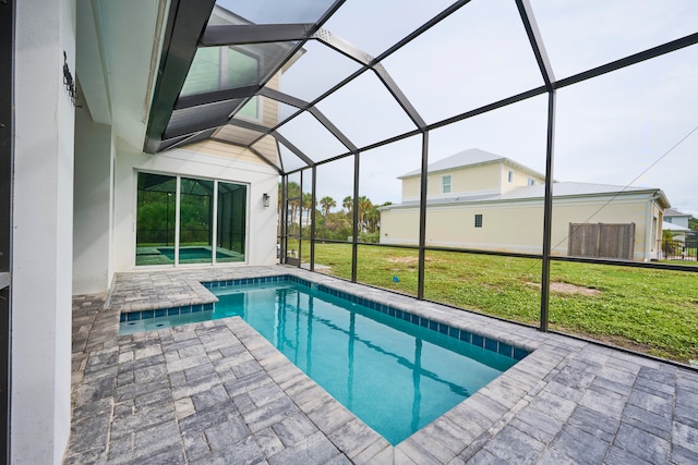 view of pool with a patio, glass enclosure, and a yard