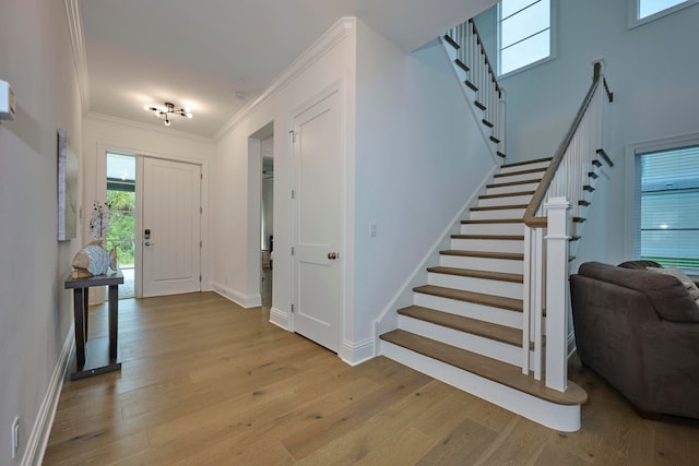 entrance foyer featuring ornamental molding and light hardwood / wood-style floors