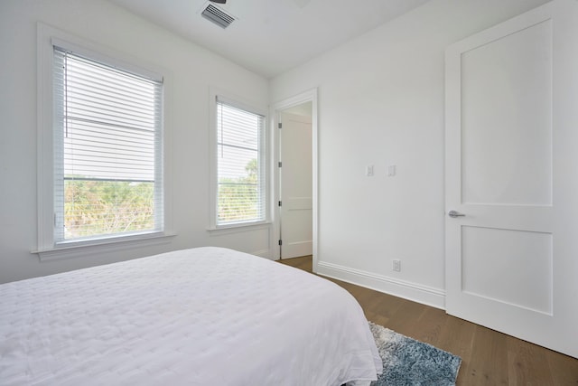 bedroom with dark hardwood / wood-style floors