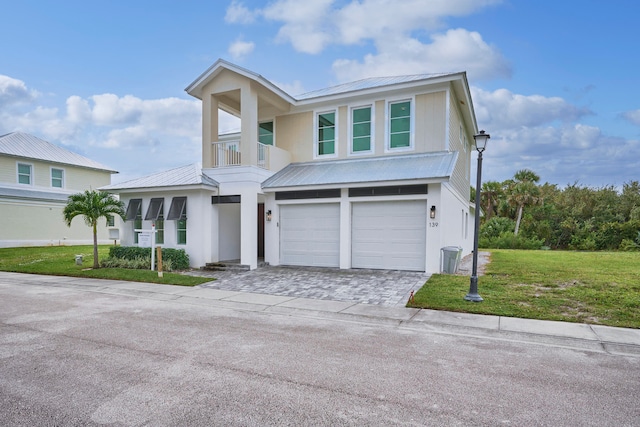 view of front of home with a front lawn, a garage, and a balcony