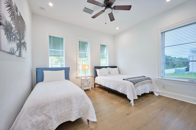 bedroom with multiple windows, light wood-type flooring, and ceiling fan