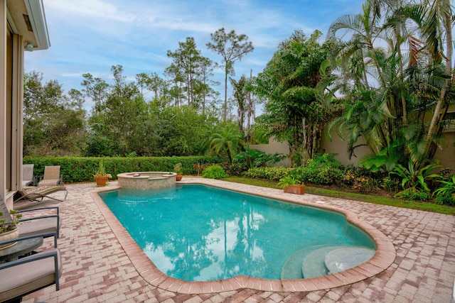 view of swimming pool with an in ground hot tub and a patio area