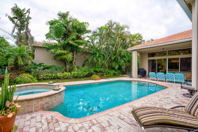 view of pool with an in ground hot tub and a patio area