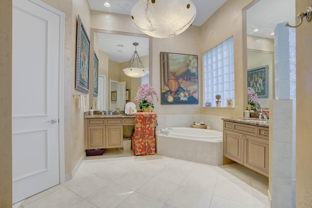 bathroom featuring vanity, a relaxing tiled tub, and tile patterned flooring