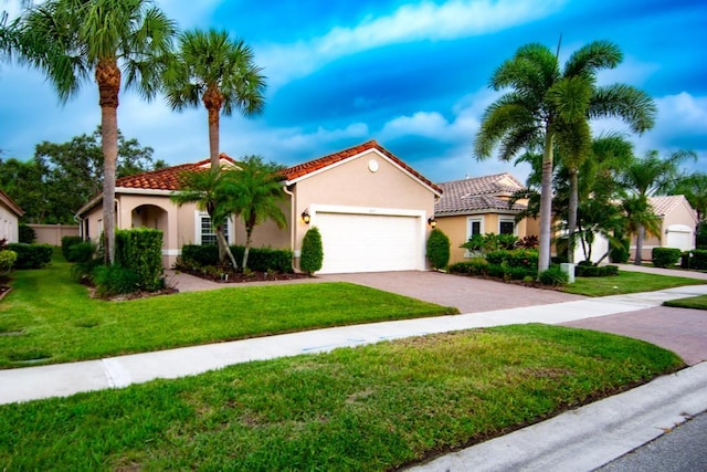 mediterranean / spanish-style home featuring a front lawn and a garage