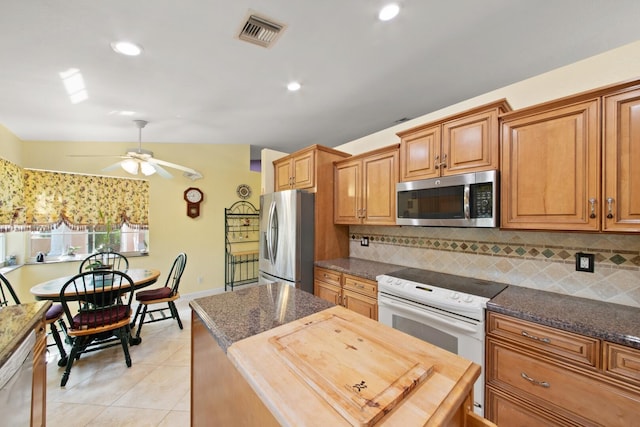 kitchen featuring lofted ceiling, ceiling fan, backsplash, wooden counters, and stainless steel appliances