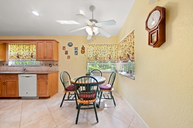 tiled dining room featuring a healthy amount of sunlight, sink, and ceiling fan