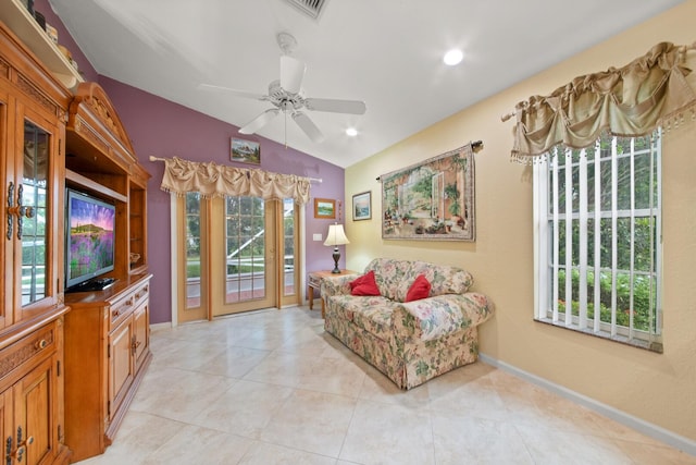 living area with vaulted ceiling, light tile patterned flooring, and ceiling fan