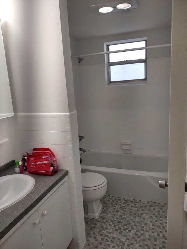 full bathroom with tiled shower / bath, vanity, tile patterned flooring, and toilet